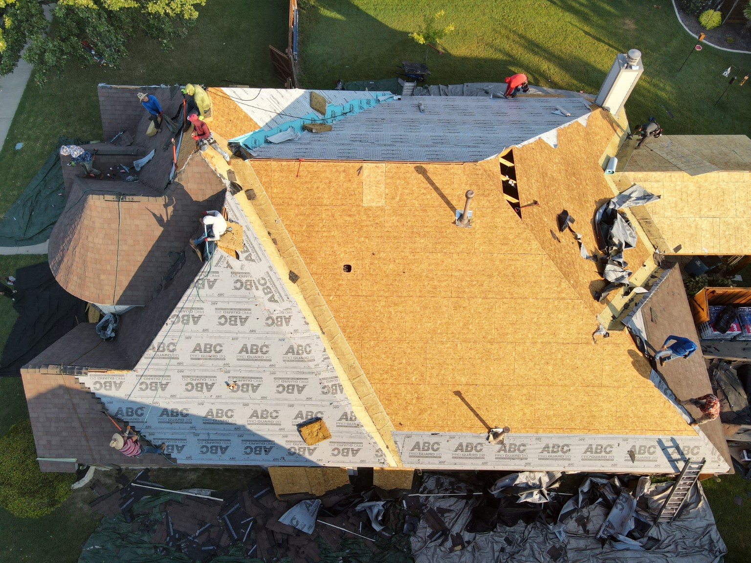 Element crew installing a roofing system with decking and underlayment exposed